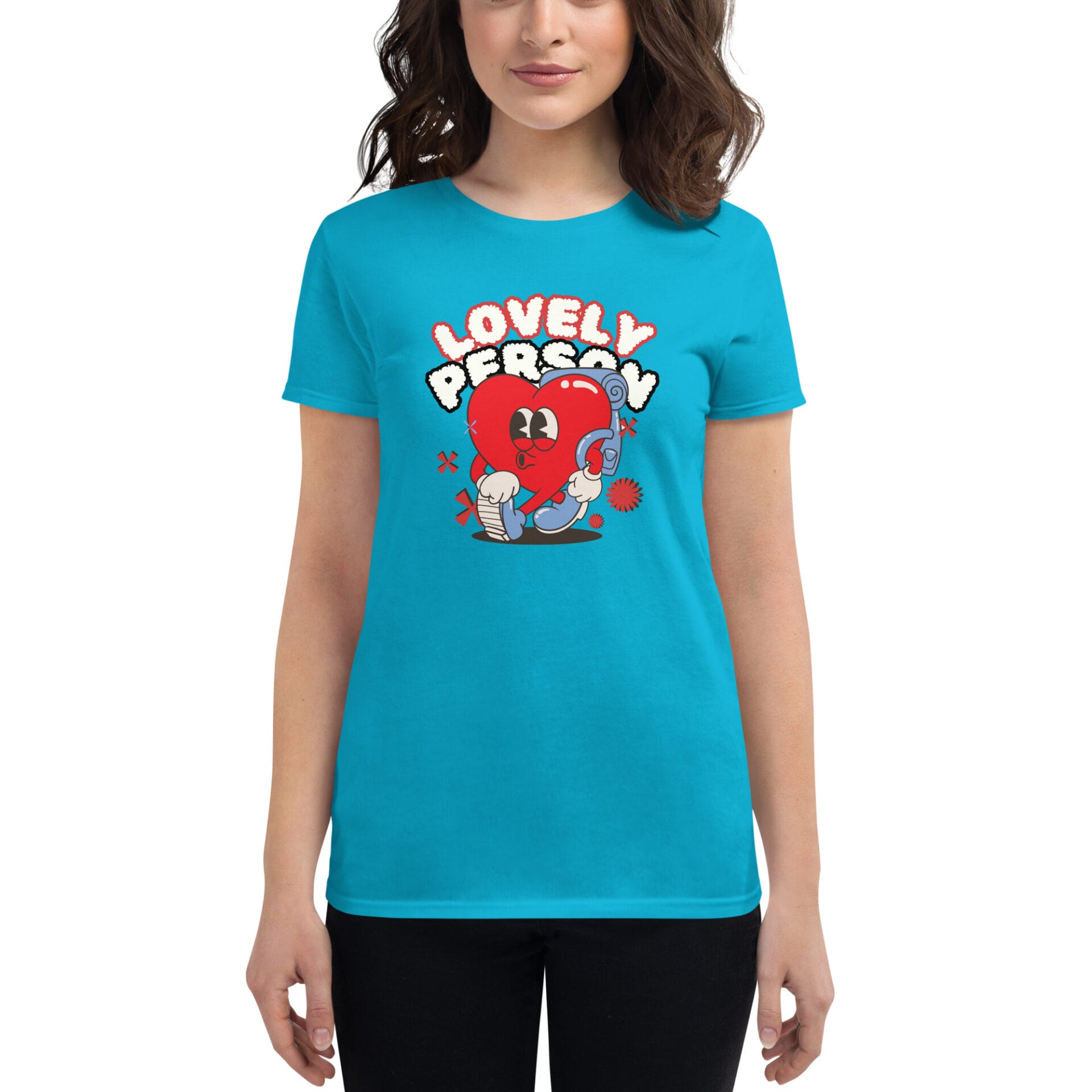 A person wears a bright turquoise t-shirt featuring a cartoon heart character with boxing gloves and the text "LOVELY PERSON" in playful colorful letters against a simple backdrop.