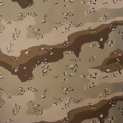 A camouflage fabric displays various earth-toned patterns with patches of dark brown and lighter beige shades creating a textured appearance suitable for blending into natural environments.