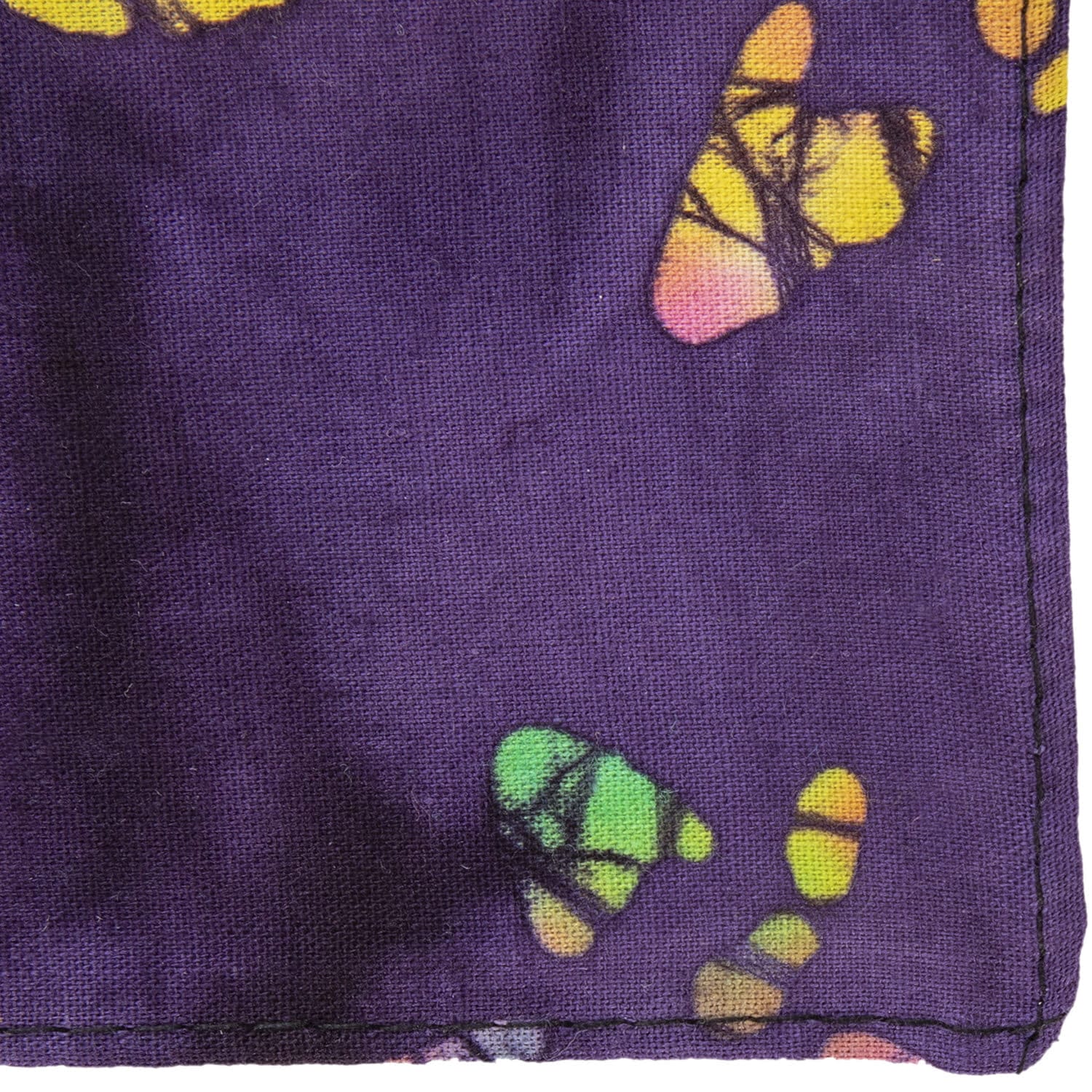 A purple fabric features colorful butterfly patterns in yellow pink green and orange showcasing a textile design with intricate details and vibrant colors likely used for clothing or home decor.