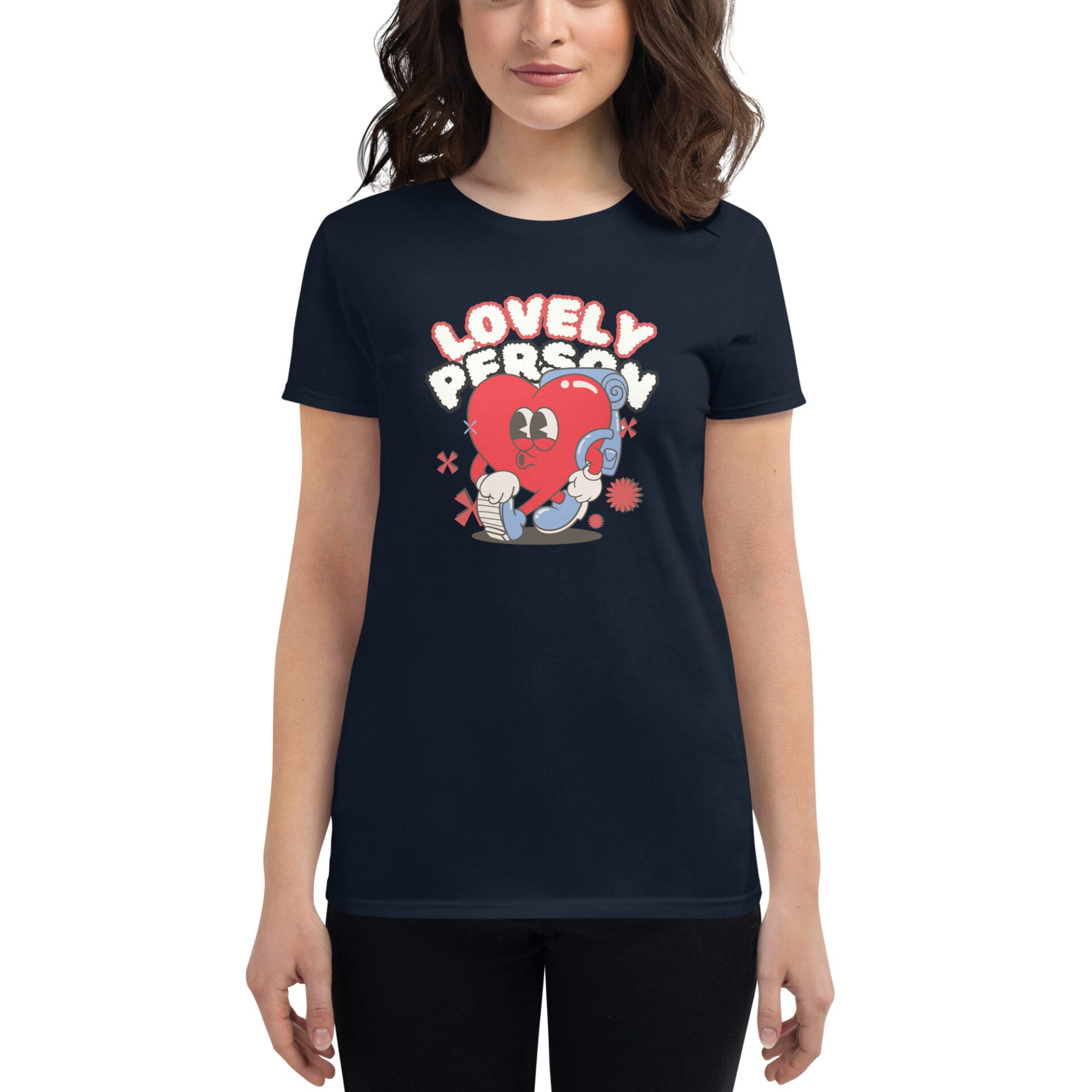 A woman wears a dark t-shirt featuring a cartoon heart character hugging a blue object with the text "LOVELY PERSON" above it in a playful design.